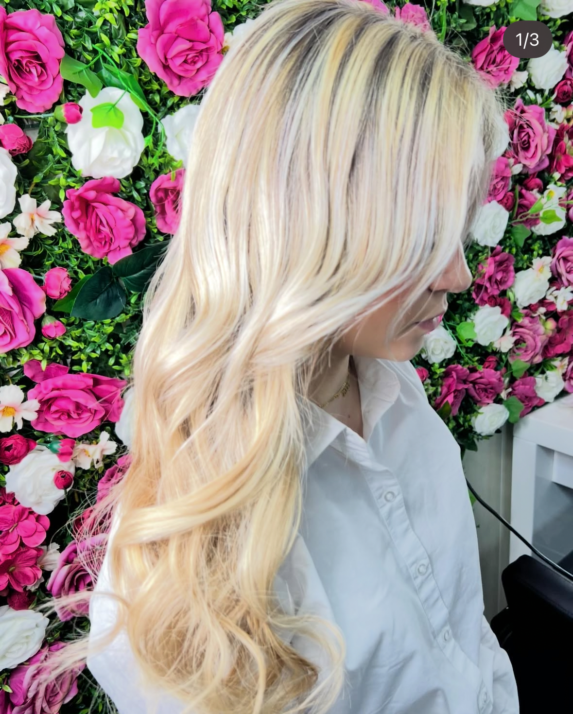 Een haarstylist die zorgvuldig haarextensions aanbrengt bij een klant in een moderne kapsalon, met een focus op de techniek en de verschillende soorten extensions die worden gebruikt voor een natuurlijke uitstraling.