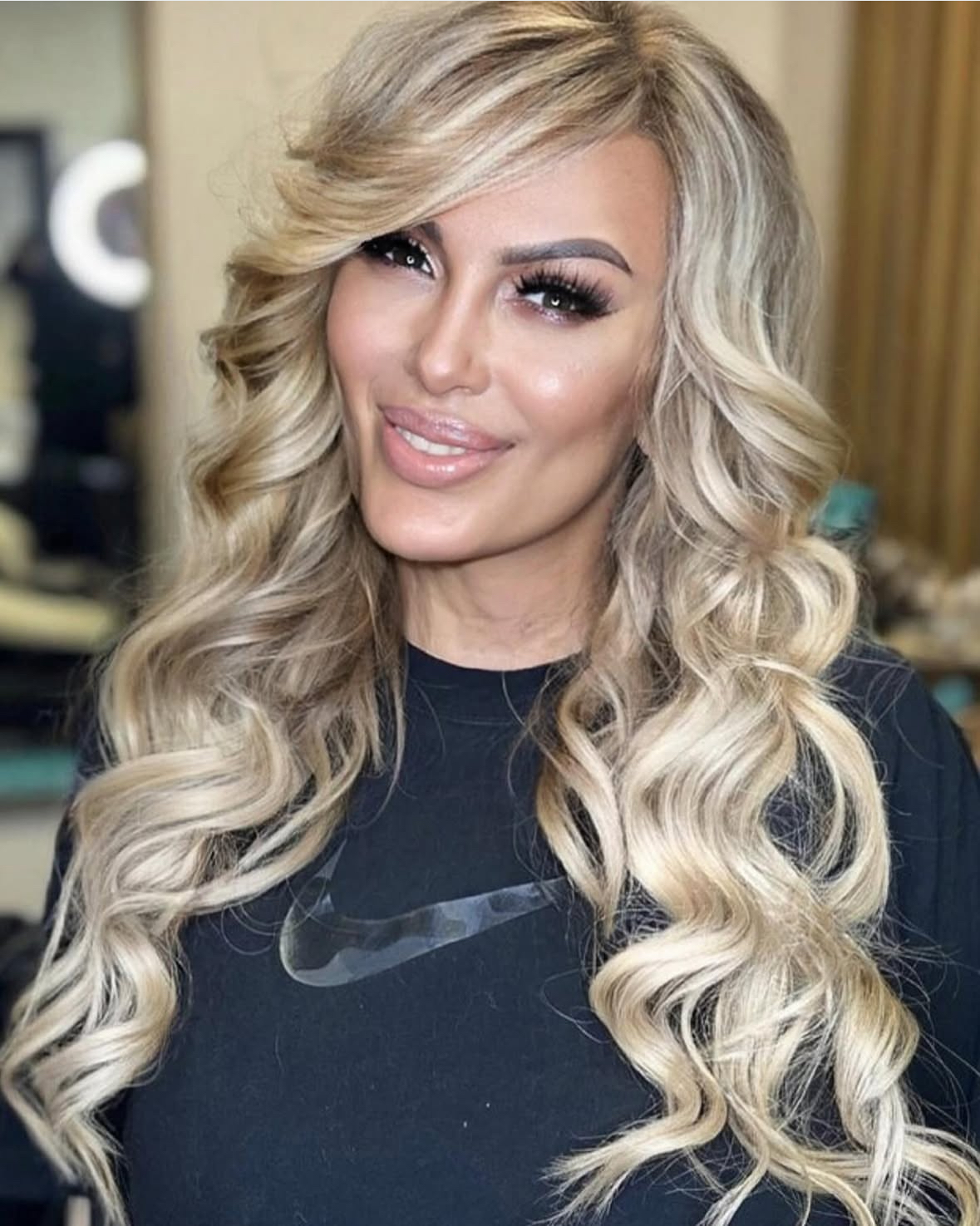 lose-up van glanzende, volle hairextensions in Den Haag, perfect geplaatst op natuurlijk haar, met een professionele salonomgeving op de achtergrond, benadrukt de kwaliteit en vakmanschap van de hairstylist die gespecialiseerd is in het aanbrengen van hairextensions voor een natuurlijke en langdurige look